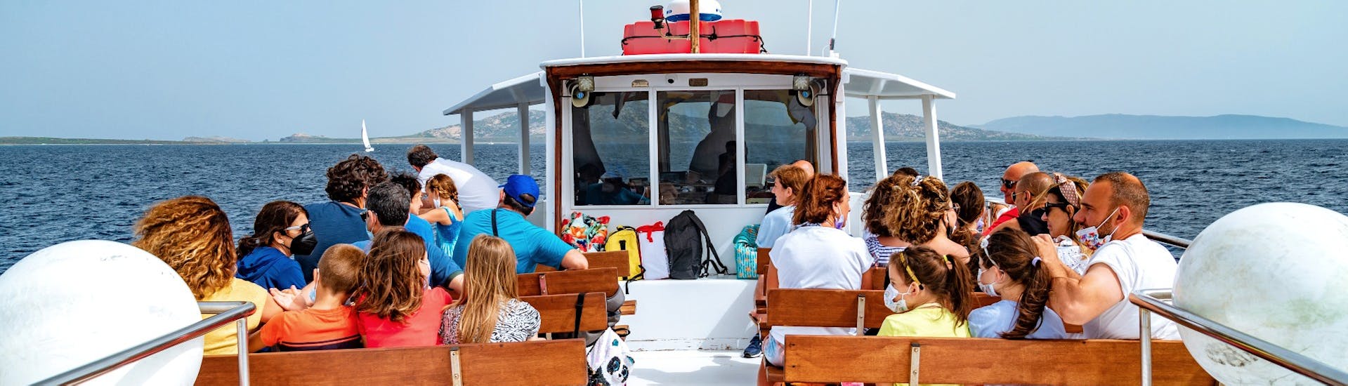 Gente sentada en la cubierta superior durante el traslado en barco de Stintino a Asinara con la Linea del Perco dell'Asinara.
