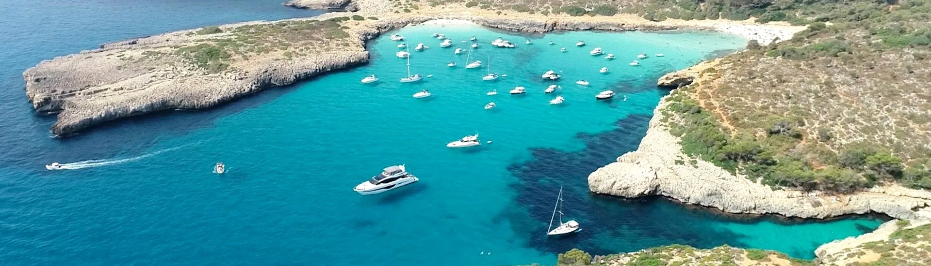 A group of boats sailing during a Private Full Day Boat Trip from Porto Cristo with Sailing Porto Cristo.