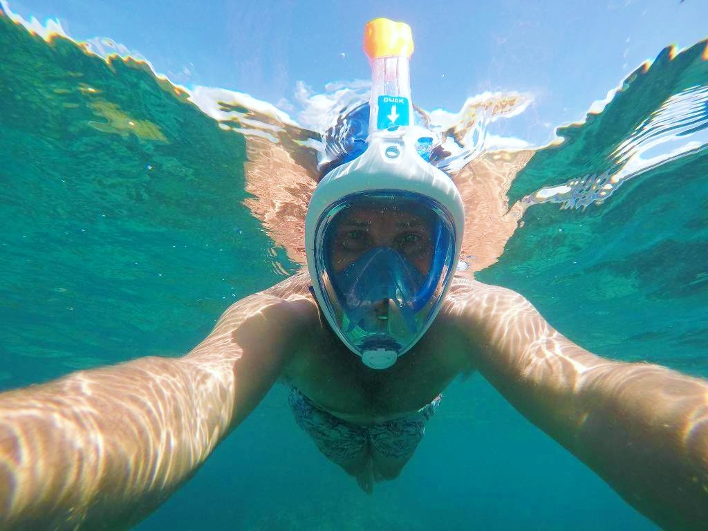 A young man is doing a Snorkeling Trip around Cargèse in Corsica with À l'Eau Rando.