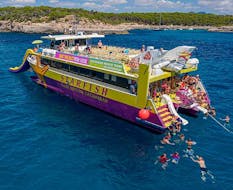 Mensen genieten van een bad tijdens een catamarantrip met glazen bodem naar Cala Figuera met zwemmen en snorkelen met zeesterren met glazen bodemboten.