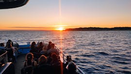 Menschen auf einem Boot von 5emotions Portimão beobachten den Sonnenuntergang bei der Bootstour bei Sonnenuntergang mit Delfin-Beobachtung.