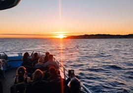 Un gruppo di persone sulla barca di 5emotions Portimão osservando il tramonto durante il giro in barca al tramonto con Osservazione dei Delfini.