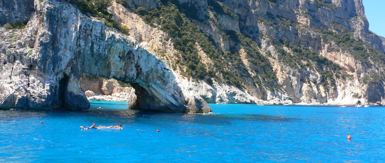 View of the rock arch of Cala Goloritzè with some people in the water during our Boat Rental in Arbatax (up to 8 people - with licence) with Flamar Vacanze Arbatax.