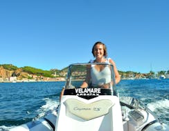 Une femme conduit le semi-rigide lors de la location de bateau à Arbatax avec permis de Velamare Arbatax.