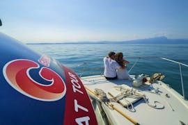Twee toeristen genieten van een boottocht van Peschiera del Garda naar Sirmione met GardaVoyager.