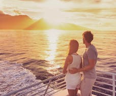 Una pareja apreciando la puesta de sol desde nuestro catamarán durante una excursión en catamarán a la Cova Tallada con Boramar Denia.