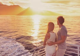 A couple appreciating the sunset from our catamaran during a Sunset Catamaran Trip to Cova Tallada with Boramar Denia.