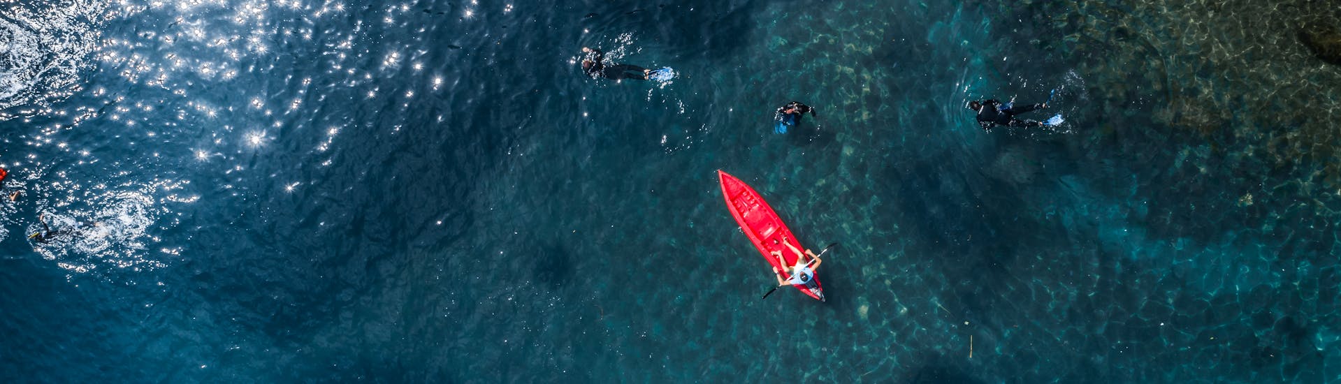 Persone che fanno snorkeling e sui kayak durante il nostro Giro in kayak a Portofino con snorkeling e aperitivo con Outdoor Portofino.
