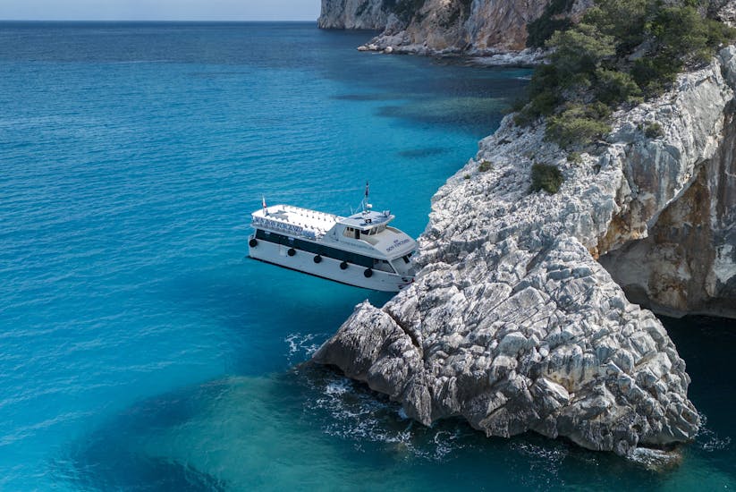 The boat is navigating under a rock formation during the Boat Transfer to the Bue Marino Caves from Cala Gonone with Dovesesto.