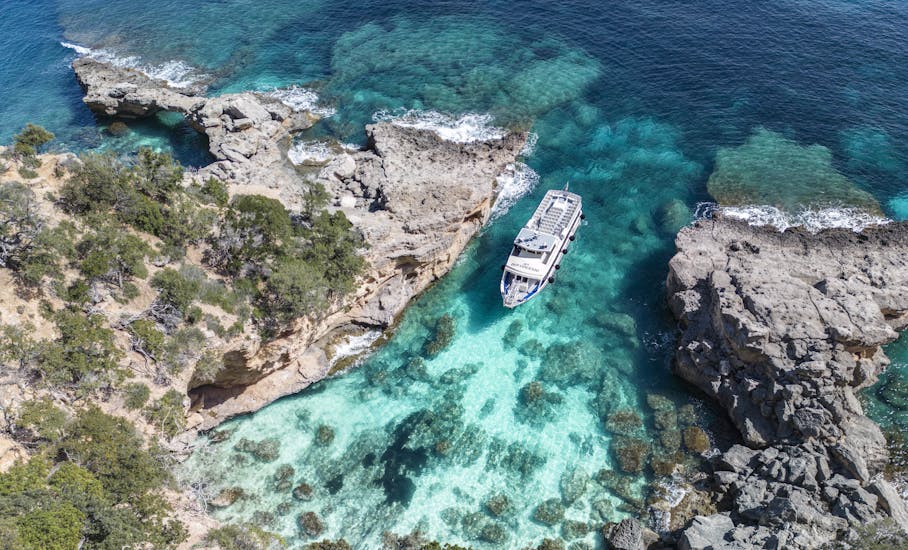 Aerial view of the boat entering the caves during the Day Trip to the Bue Marino Caves & Cala Luna with Dovesesto.