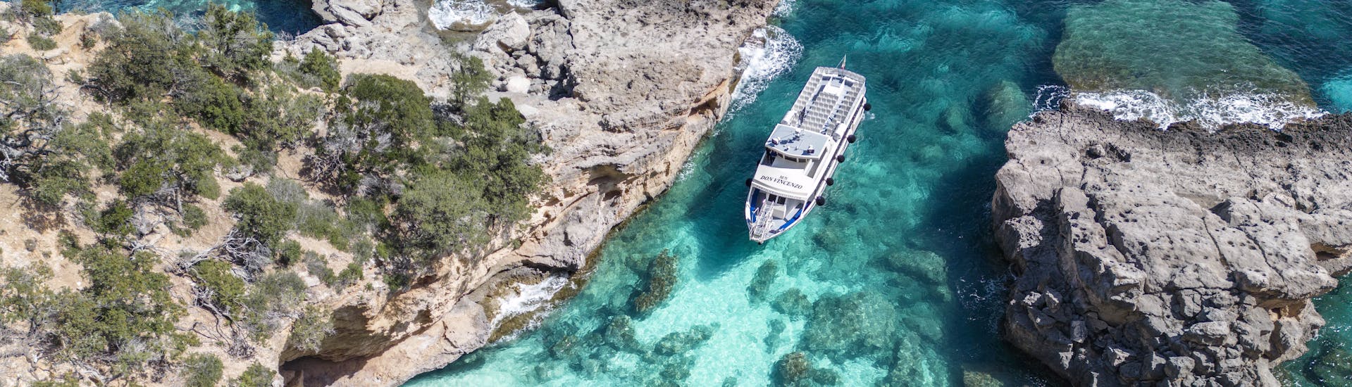 Aerial view of the boat entering the caves during the Day Trip to the Bue Marino Caves & Cala Luna with Dovesesto.