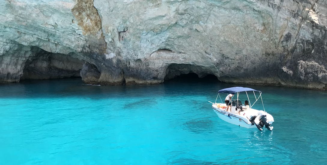 Private boat rented from Porto Vromi Maries anchored in front of small caves.