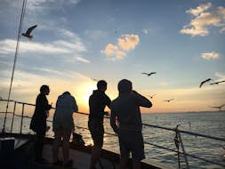 Menschen beobachten den Sonnenuntergang bei der Bootstour bei Sonnenuntergang mit Delfinbeobachtung ab Pula mit Orion Travel Pula.