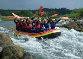 Een groep vrienden juichen tijdens het raften op de rivier de Iller in Allgäu - Alles in één vlot met Spirits of Nature Allgäu.