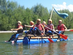 Een groep vrienden peddelt op hun vlot tijdens het vlot bouwen op de Iller River in Allgäu met Spirits of Nature Allgäu.