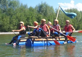 A group of friends is paddling on their raft during the Raft Building on the Iller River in Allgäu with Spirits of Nature Allgäu.