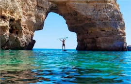 Participante en el Stand-up-paddle en una cueva durante el alquiler de SUP en la playa de Benagil con Algarve Discovery.
