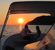 Una joven pareja disfruta de la puesta de sol durante el paseo en barco al atardecer por Cinque Terre, con aperitivo, con Sea Breeze Boat Tours Levanto.