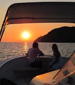 Ein junges Paar genießt den Sonnenuntergang während einer Bootstour bei Sonnenuntergang entlang der Cinque Terre mit Aperitif von Sea Breeze Boat Tours Levanto.