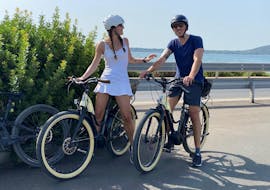 Twee vrienden nemen een pauze terwijl ze met Bike & Boat Argentario op de E- City Bike in de Toscaanse Maremma toeren.