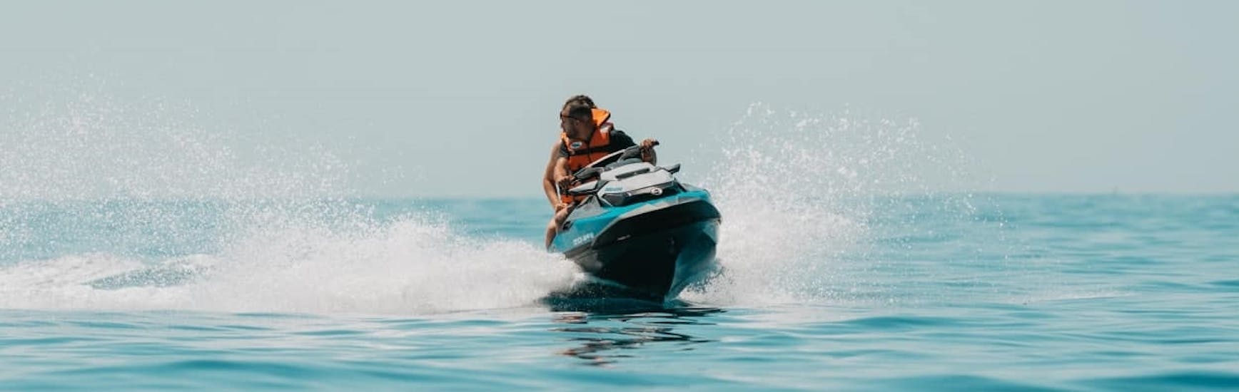 Ein Mann, der während einer Jetski-Safari in der Bucht von Alcudia mit GoJet Jet Ski Mallorca im Meer fährt.