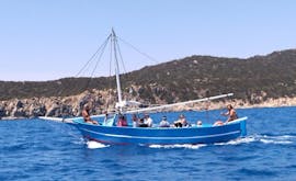 Bateau en bois avec des personnes à bord naviguant pendant la Balade en bateau de Villasimius à Punta Molentis avec Tour Express Villasimius.