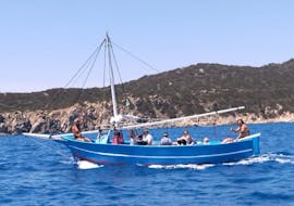 Barco de madera con personas a bordo navegando durante la excursión en barco de Villasimius a Punta Molentis con Tour Express Villasimius.