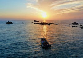 Alcune persone fanno un giro in barca al tramonto alle Isole Sanguinarie con Corsica Croisières Ajaccio.