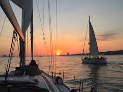 Two sailing boats navigating into the sunset during the Sunset Boat Trip from Lisbon on the Tagus River with Palmayachts Charters Portugal.