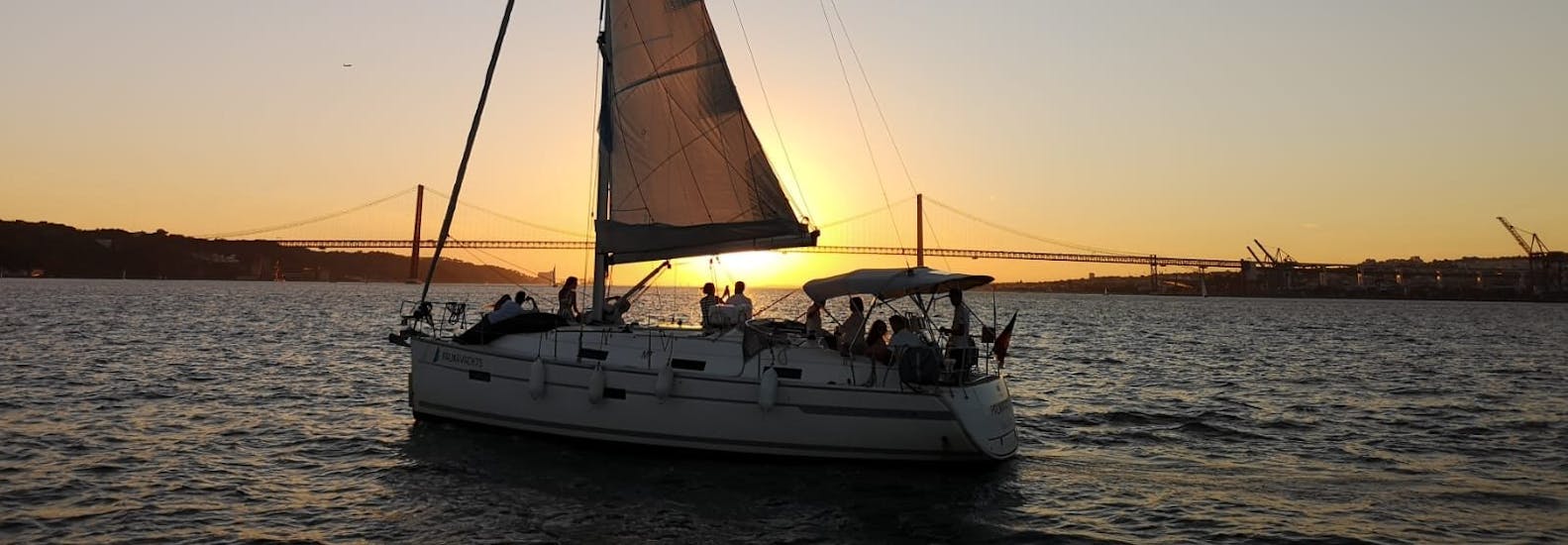 Un groupe lors de la balade en bateau au coucher du soleil depuis Lisbonne sur le fleuve Tage avec Palmayachts Charters Portugal.