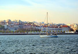 Ein Boot vor der Altstadt während der Bootstour in die Altstadt Lissabons auf dem Tagus mit Palmayachts Charters Portugal.