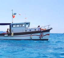La barca in legno cabinata di Tour Express Villasimius che naviga durante la Gita in barca privata da Villasimius a Punta Molentis.