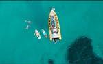 Deelnemers op een speedboot omringd door turquoise wateren in de baai van Alcudia tijdens een boottocht van Can Picafort naar het natuurpark Llevant met North Coast Adventure Mallorca.