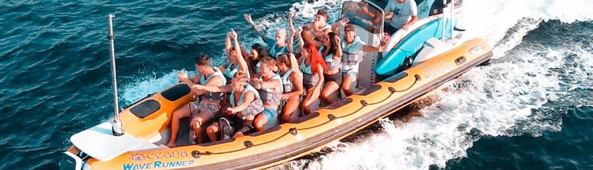 Die Teilnehmer auf einem Schnellboot, umgeben von plätscherndem Wasser in der Bucht von Alcúdia, während einer Bootstour von Can Picafort zum Naturpark Llevant mit North Coast Adventure Mallorca, haben viel Spaß.