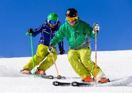 2 skiers are going down the slopes during private ski lessons for adults with ski school Snow Experts Pass Thurn.