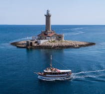 Le bateau est ancré devant le phare de Porer, lors de la balade en bateau autour de l'archipel de Medulin avec Déjeuner organisée par Tajana & Zlatni Rat Excursions Medulin.