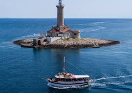Le bateau est ancré devant le phare de Porer, lors de la balade en bateau autour de l'archipel de Medulin avec Déjeuner organisée par Tajana & Zlatni Rat Excursions Medulin.