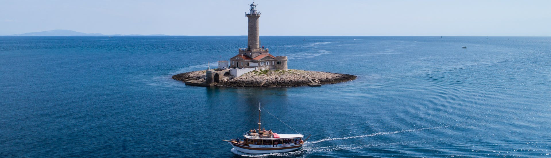 Photo du bateau devant le phare de Porer, pendant la balade en bateau autour de l'archipel de Medulin avec Déjeuner organisée par Tajana & Zlatni Rat Excursions Medulin.