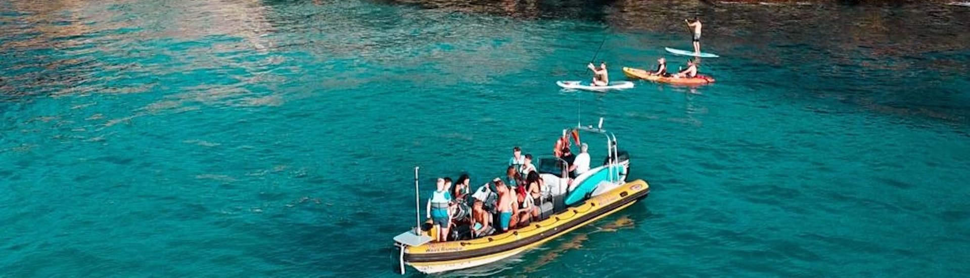 Participants on a speedboat stopping for a swim in the turquoise waters in Alcudia Bay during a boat trip from Can Picafort to Llevant Natural Park with North Coast Adventure Mallorca.