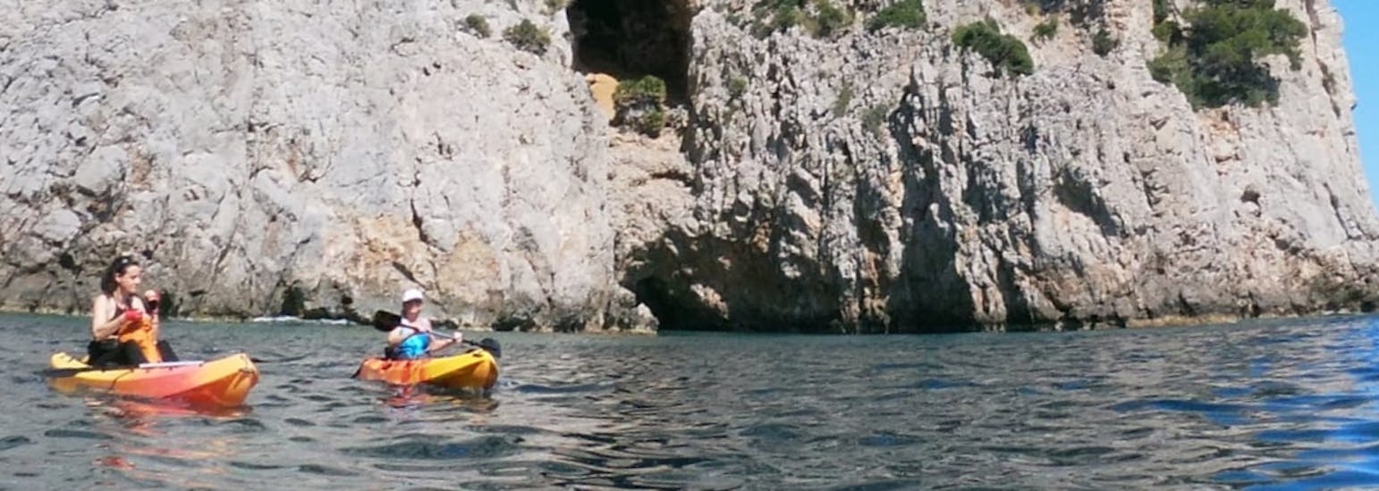 Eine Familie hat Spaß beim Paddeln durch die Bucht von Alcúdia beim Kajakverleih am Strand von Alcanada mit North Coast Adventure Mallorca.