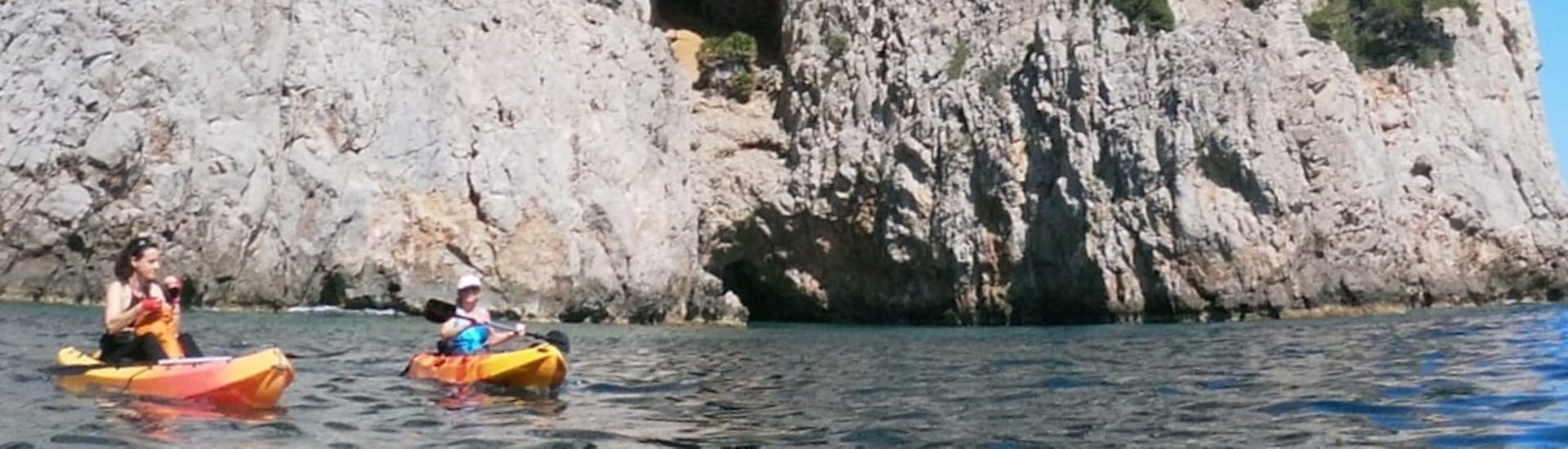 Una familia se divierten remando por la bahía de Alcudia durante un alquiler de kayak de mar en la playa de Alcanada con North Coast Adventure Mallorca.