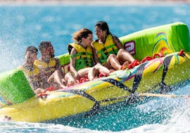 Un grupo de amigos disfrutando de un Banana Boat y otros hinchables en la Costa del Sol con Fuengirola Sea Trips.