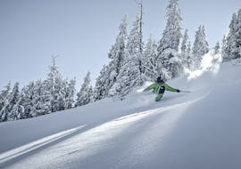 Un skieur profite de la poudreuse pendant les cours particuliers de ski hors-piste de l'école de ski Snow Experts Pass Thurn.