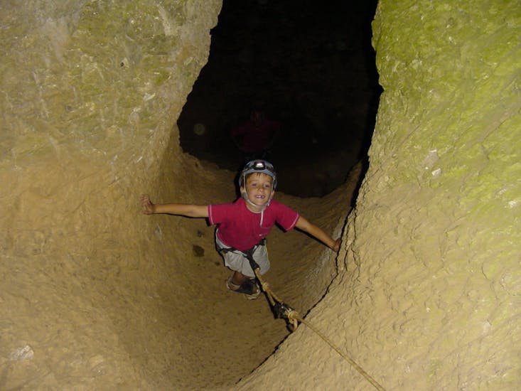 Little boy exploring the Cotepatière cave during the family caving in South Ardèche with Cévèn' Aventure.