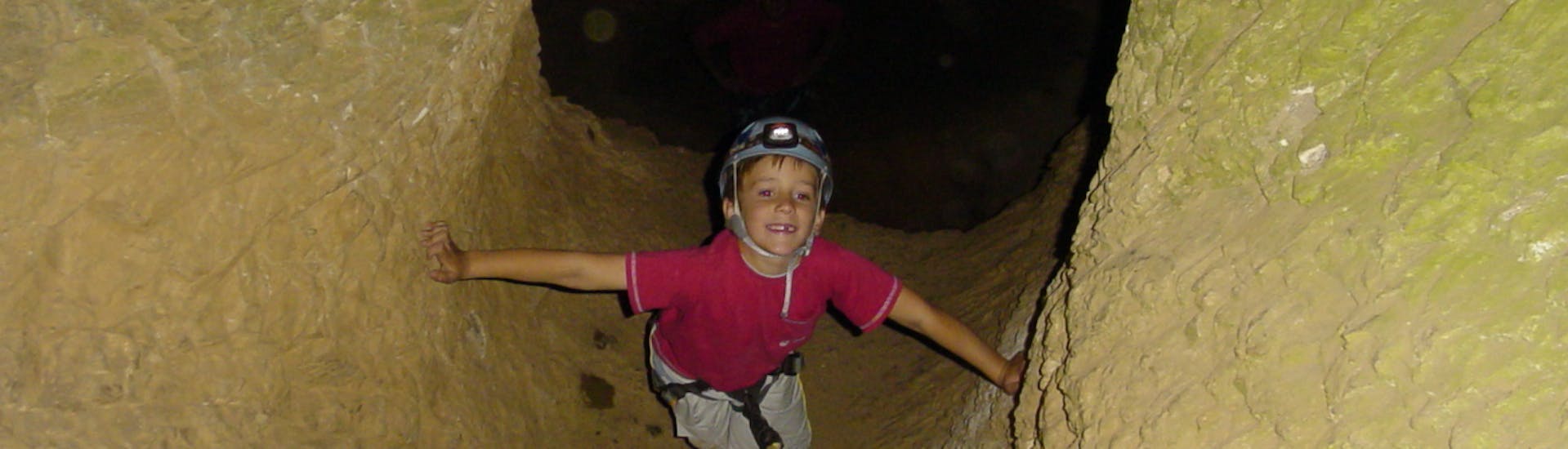 Little boy exploring the Cotepatière cave during the family caving in South Ardèche with Cévèn' Aventure.