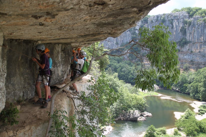 Participants faisant la via corda en Sud Ardèche sur un flanc de montagne avec Cévèn'Aventure.