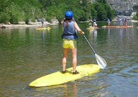 Woman standing on the paddle during the Stand Up Paddleboarding tour in South Ardèche with Cévèn'Aventure.