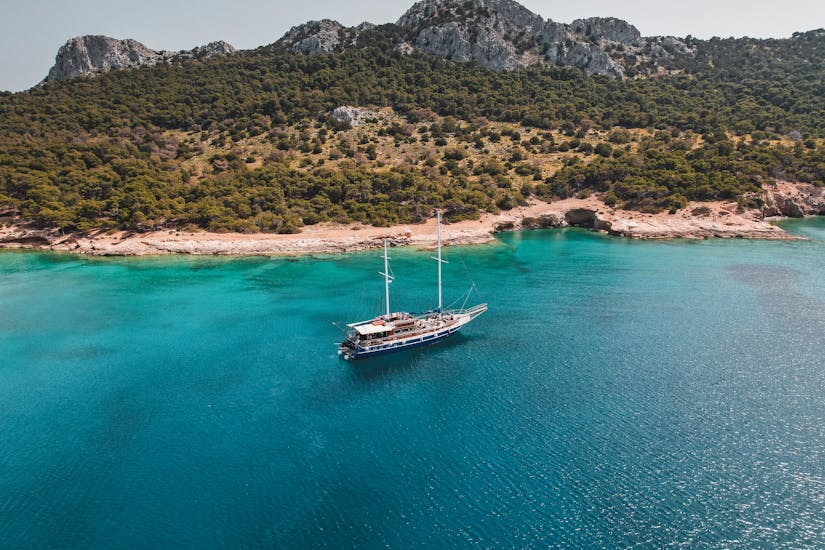 The island of Moni with the boat, which can be visited on the sailing tour to Agistri, Moni and Aegina with All Day Cruises.