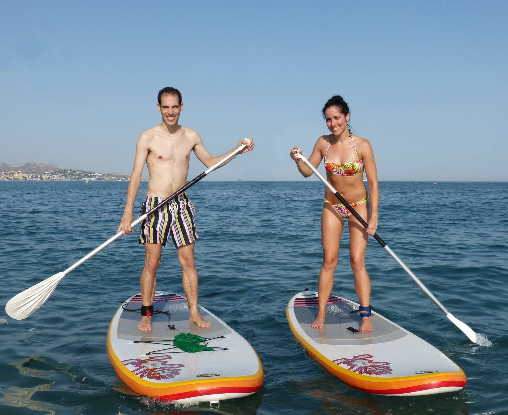 Friends practising SUP Lessons on Malagueta Beach for Beginners with Malagawake.