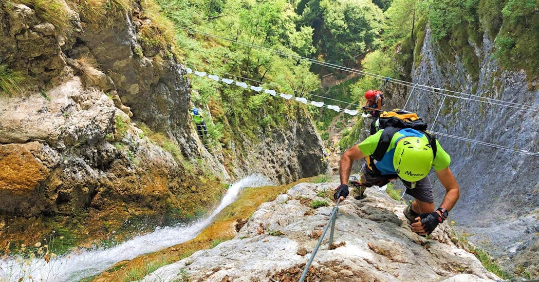 Uomo che arrampica una roccia durante un'attività sulla via ferrata Signora delle Acque a Ballino con Mmove Into Nature.